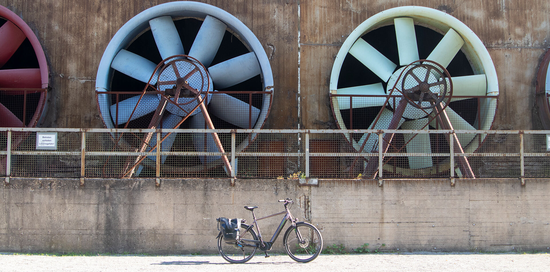 Blick auf ein Lüftergebläse auf Zollverein, davor ein E-Bike.