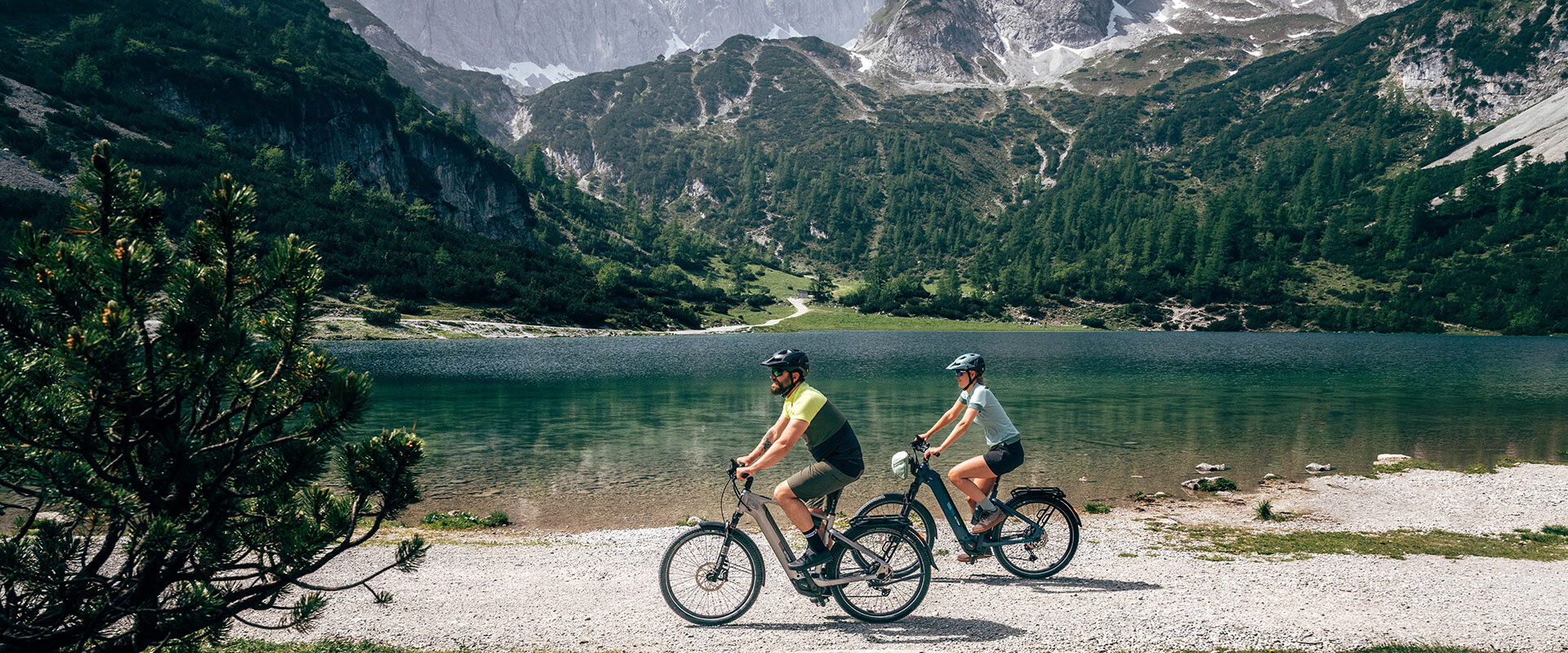 Un couple roule le long des rives d'un lac de montagne.