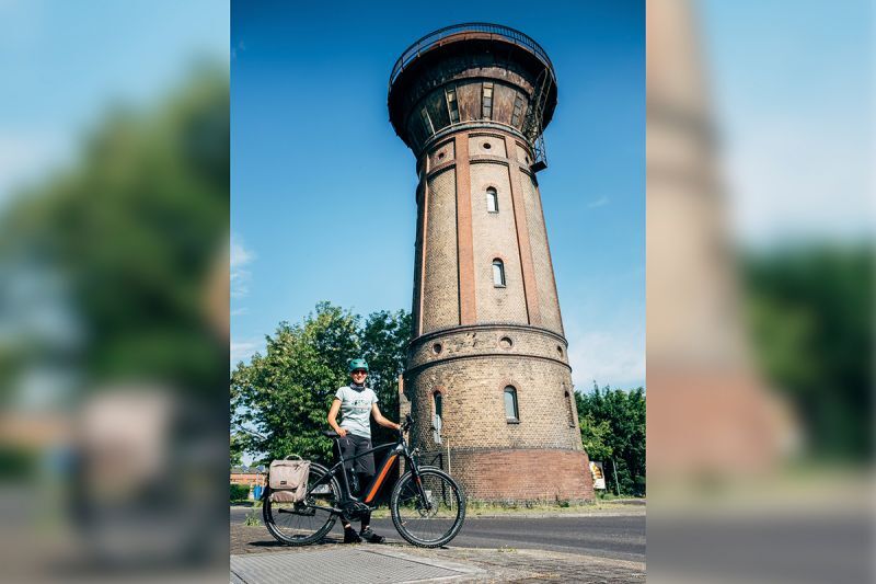 Frau mit einem E-Bike vor dem Wasserturm in Hoyerswerda