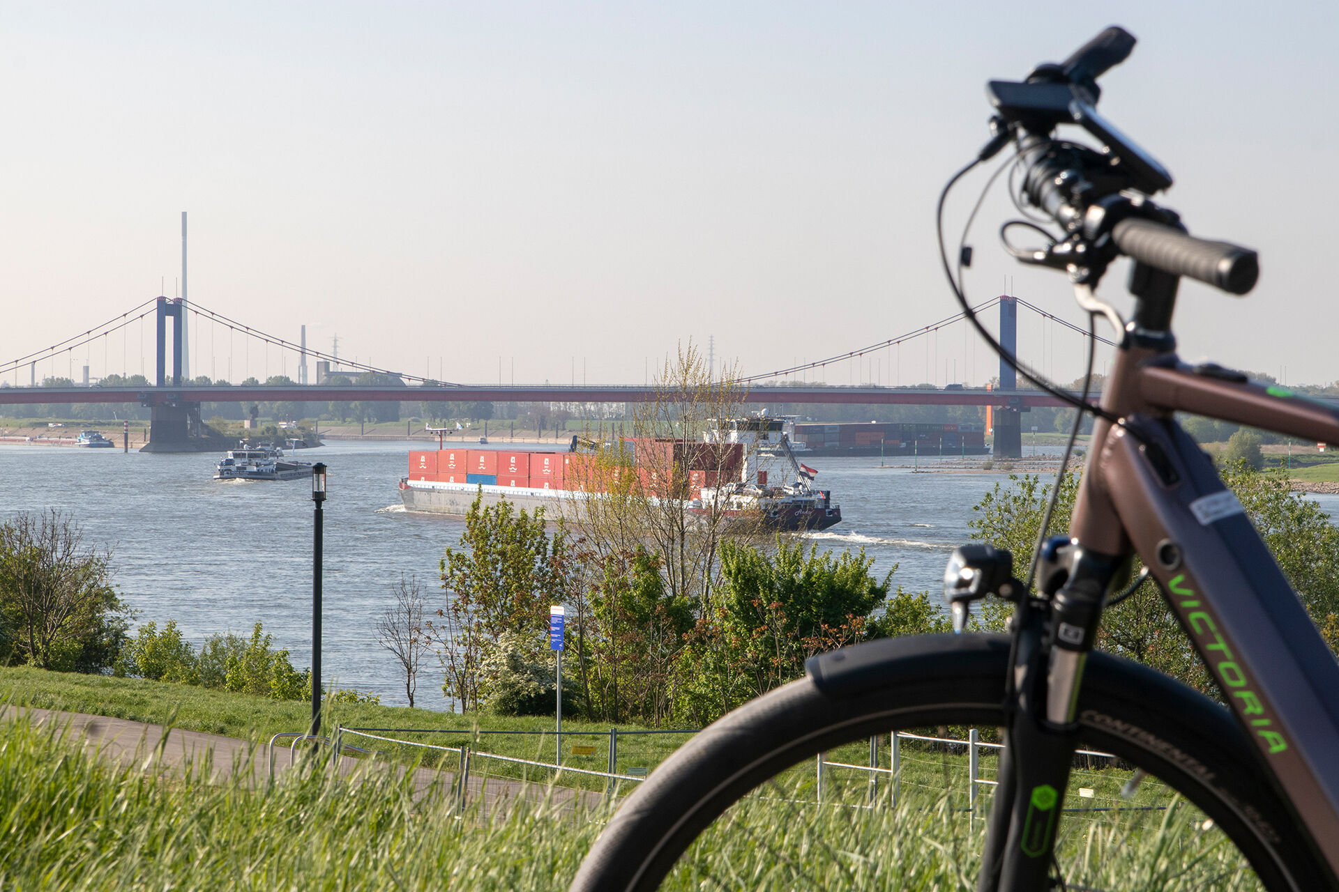  E-Bike steht im Vordergrund, im Hintergrund ist die  Friedrich-Ebert-Brücke Eisenbahnbrücke zu erkennen